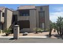 Exterior shot of a tan building with a tile roof, stone accents and desert landscaping at 5995 N 78Th St # 2004, Scottsdale, AZ 85250