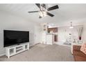 Open-concept living area with neutral colors, ceiling fan, and access to the kitchen and front door at 5995 N 78Th St # 2004, Scottsdale, AZ 85250