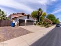Charming home featuring a three car garage, beautiful landscaping, and desert plants in the front yard at 6154 E Karen Dr, Scottsdale, AZ 85254