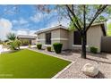 Exterior view of home featuring rocks for landscaping with a lush green lawn at 6204 W Hedgehog Pl, Phoenix, AZ 85083