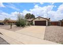Inviting home exterior featuring a well-maintained driveway and desert landscaping at 6313 W Paradise Ln, Glendale, AZ 85306
