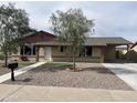 Charming single-story home with low-maintenance rock landscaping and a covered carport at 7136 W Cheryl Dr, Peoria, AZ 85345