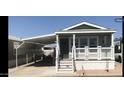Charming home exterior with covered carport, covered front porch and desert landscaping at 8700 E University Dr # 124, Mesa, AZ 85207
