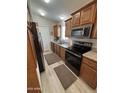 Functional kitchen with wooden cabinetry, modern appliances, and light wood flooring at 8700 E University Dr # 124, Mesa, AZ 85207