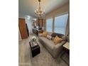 Comfortable living room with wood floors, modern decor, chandelier, and kitchen access at 8700 E University Dr # 124, Mesa, AZ 85207