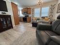 Cozy living room featuring light wood floors, a chandelier, and open access to the kitchen at 8700 E University Dr # 124, Mesa, AZ 85207