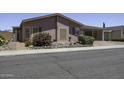 Charming single-story home with a covered carport and desert landscaping featuring a colorful flowering bush at 880 W Moon Shadow Dr, Casa Grande, AZ 85122