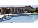 Sparkling pool with access stairs, a table setting, and well-maintained landscaping at 880 W Moon Shadow Dr, Casa Grande, AZ 85122