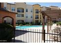 Inviting community pool with a secure fence and comfortable lounging areas in a landscaped complex at 14575 W Mountain View Blvd # 11212, Surprise, AZ 85374