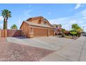 Three-car garage with an extended driveway and desert landscaping provides plenty of parking at 16040 W Grant St, Goodyear, AZ 85338