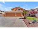 Lovely home with a three-car garage, well-maintained lawn, mature desert landscaping, and tiled roof at 16040 W Grant St, Goodyear, AZ 85338