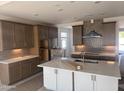 Modern kitchen features updated stainless appliances, light countertops, custom cabinets, and a center island at 17747 W Brown St, Waddell, AZ 85355