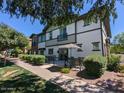 Beautiful condo exterior with back patio and seating area, shaded by mature trees, perfect for relaxing at 1814 E Bridgeport Pkwy # 103, Gilbert, AZ 85295