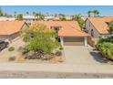 Wide aerial shot of the house nestled in a community with terra cotta rooftops and desert landscaping at 19443 N 36Th St, Phoenix, AZ 85050