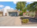 Inviting single-story home featuring a gray garage door and desert landscaping with colorful flowers at 2170 E Alameda Dr, Tempe, AZ 85282
