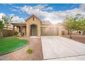 Beautiful home featuring a stone archway, neutral paint, a well-maintained lawn, and a two-car garage at 21972 N 97Th Gln, Peoria, AZ 85383
