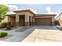 Charming single-story home with a two-car garage, covered porch, and landscaped front yard at 23195 S 226Th Way, Queen Creek, AZ 85142