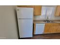 Kitchen with wood cabinets, laminate countertops, and white appliances at 23424 W Pima St, Buckeye, AZ 85326