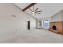 Bright living room showcasing vaulted ceilings, a cozy brick fireplace, and ample natural light, and neutral carpet at 2346 E Jasmine St, Mesa, AZ 85213