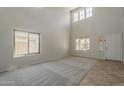 Bright living room featuring high ceilings, neutral carpet, and lots of natural light with many windows at 2408 W Saint Kateri Dr, Phoenix, AZ 85041