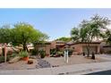 Attractive single-story home featuring desert landscaping, stone accents, and mature trees at 32472 N 68Th Pl, Scottsdale, AZ 85266