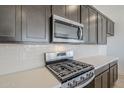 Modern kitchen with stainless steel appliances, subway tile backsplash, and custom cabinetry at 35524 N Tin Ct, San Tan Valley, AZ 85144