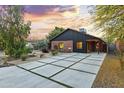 Charming single-story home with red brick and modern siding, well-manicured yard, and a long concrete driveway with grass accents at 358 E Whitton Ave, Phoenix, AZ 85012