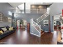 Spacious living room with high ceilings, wood floors, and a staircase leading to an open loft area at 3679 S Cottonwood Ct, Chandler, AZ 85286