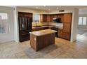 Spacious kitchen with tile floors, center island, stainless steel appliances, and wood cabinets at 4613 W Fawn Dr, Laveen, AZ 85339