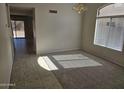 Sunlit living room featuring plush carpet, neutral paint, tile entry, and traditional lighting fixture at 4613 W Fawn Dr, Laveen, AZ 85339