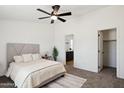 Bright main bedroom with neutral tones, a ceiling fan, and an en-suite bathroom at 51288 W Bluejay St, Maricopa, AZ 85139