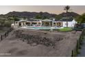 Expansive backyard featuring a modern pool, covered patio, and partially landscaped grounds with mountain views at 7100 N 47Th St, Paradise Valley, AZ 85253