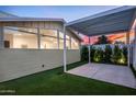 Backyard patio area with a pergola, artificial grass, and vibrant sunset views at 7646 E Catalina Dr, Scottsdale, AZ 85251