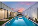 A backyard oasis featuring a sparkling pool, privacy walls, and artificial turf at 7646 E Catalina Dr, Scottsdale, AZ 85251
