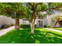 Beautiful two-story condo with manicured lawn, mature trees, and secure gated entry at 7684 E Minnezona Ave, Scottsdale, AZ 85251