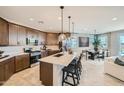 Spacious kitchen flows into dining and living areas, featuring stainless steel appliances and island seating at 8142 E Petra Ave, Mesa, AZ 85212