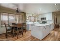 Bright kitchen featuring an island, white cabinets, modern appliances, and an adjacent dining area at 8469 W Emile Zola Ave, Peoria, AZ 85381