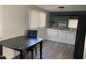 Eat-in kitchen area with black dining table and chairs with modern laminate flooring at 9913 E Main St # 40, Mesa, AZ 85207