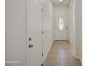 Entryway hallway featuring tiled flooring, white walls, and a decorative glass front door at 10430 E Sunflower Ln, Florence, AZ 85132