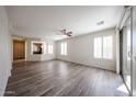 Bright living room with wood floors, ceiling fan, slider door, and multiple windows offering natural light at 12679 W Lowden Rd, Peoria, AZ 85383