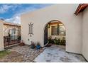 Arched entryway features an iron gate, potted plants, and a stone pathway, creating a welcoming entrance at 1602 N 73Rd Ave, Phoenix, AZ 85035