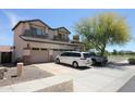 View of the side of this two story home, with a three car garage and desert landscaping at 16233 N 32Nd Ave, Phoenix, AZ 85053