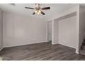 Neutral living room showcasing gray wood floors, ceiling fan, and an open layout at 17878 N 114Th Ln, Surprise, AZ 85378