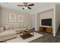 Cozy living room with L shaped couch, modern decor, ceiling fan, and grey wood floors at 17878 N 114Th Ln, Surprise, AZ 85378