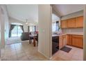 Cozy kitchen featuring wood cabinets and black appliances, adjacent to the dining area and living room at 18116 N Catherine Dr, Surprise, AZ 85374