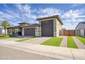 Beautiful home with manicured artificial turf, and a brick driveway leading to a spacious three-car garage at 18175 W Highland Ave, Goodyear, AZ 85395