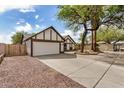 Home's exterior with gravel landscaping, two-car garage, and mature trees at 20626 N 5Th Ave, Phoenix, AZ 85027