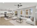Bright and airy living room with modern furnishings and seamless flow to the kitchen and dining area at 21031 E Creekside Dr, Queen Creek, AZ 85142