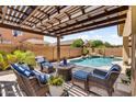 Inviting outdoor patio area with comfortable seating and a view of the pool and landscaped backyard at 21031 E Creekside Dr, Queen Creek, AZ 85142