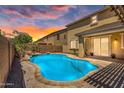 Beautiful backyard with a private pool, rock features, and mature palm trees at 21031 E Creekside Dr, Queen Creek, AZ 85142